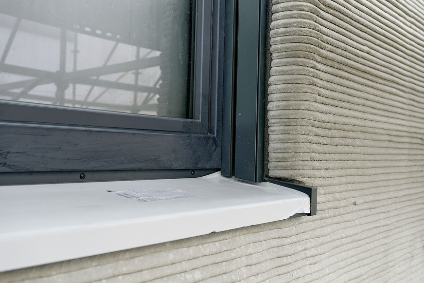 Beim Einbau der Fenster- und Türenelemente setzten die Monteure für den unteren Anschluss spezielle Unterbaudämmprofile und Fensterbankdämmkeile ein. Seitlich erfolgte die Befestigung über Laschenmontage.