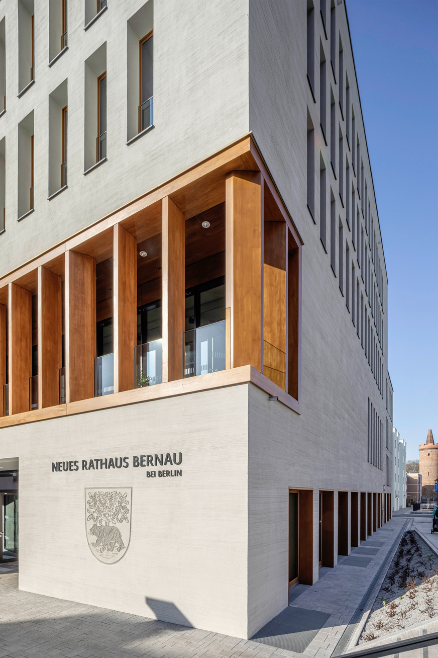 Mit dem Bären, dem Eichbaum und dem Adler in hell- und dunkelgrauen Flächen und feinen Linien hebt sich das etwa 1,75 m hohe Stadtwappen aus der Putzfassade des Neuen Rathauses in Bernau ab.