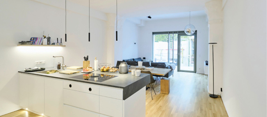 Das Zusammenspiel aus historischen Elementen und neuen Aluminium-Fenstern bewahrt den sakralen Raumeindruck und erzeugt zugleich ein modernes Wohnerlebnis.