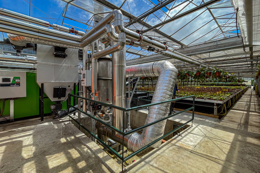 System TurbuFlexS in einem Gartenbaubetrieb: Die Hackgutheizung und der Wärmetauscher stehen im Gewächshaus der Firma Weilbrenner.