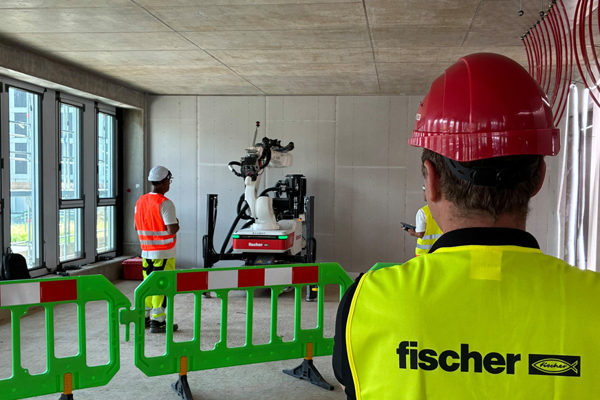 Im Herzen Frankfurts entsteht in unmittelbarer Nähe zur Messe ein neues mehrgeschossiges Bürogebäude. Für die Montage der Heizund Kühldeckenpaneele bohren zwei Fischer Baubots rund 16.000 Bohrlöcher in die Betondecken und schaffen so die Voraussetzung für die Verankerung der Paneele mit Fischer Einschlagankern EA II.