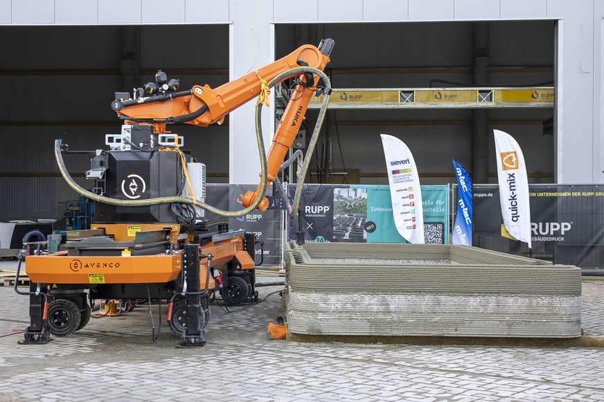 Das gedruckte Modulhaus „Pluto“ wächst durch das 7-Achs-Drucksystem und den beteiligten Projektpartnern von Rupp Gebäudedruck, Avenco, Kuka, M-Tec und Sievert.