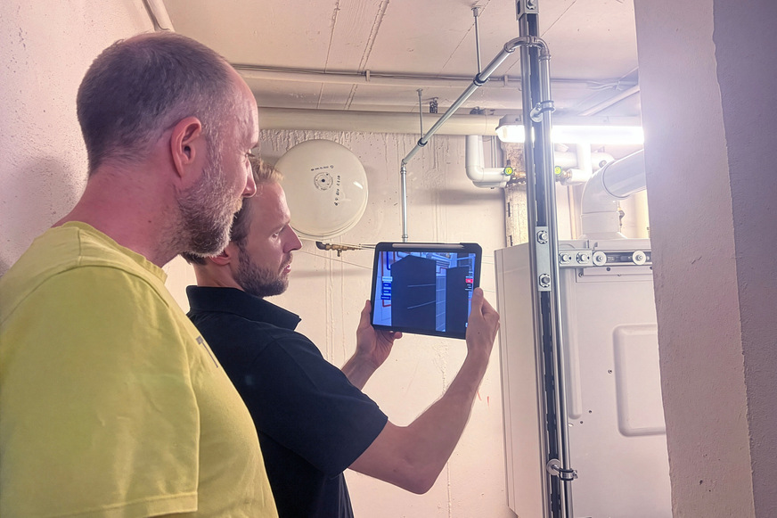Die App „Heat Pump PlanAR“ wird im Heizungskeller erprobt. Die Komponenten des Heizungsschemas werden dabei in Augmented Reality vor den Hintergrund projiziert.