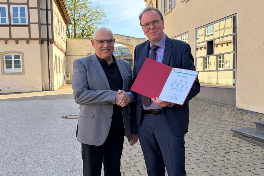 HFR-Rektor Bastian Kaiser überreicht die Urkunde an Diplom-Physiker Klaus Lambrecht (rechts).