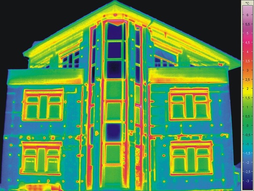 6 Außenthermografie einer gedämmten Neubaufassade, schlecht verarbeitete Dämmplatten und Dübel als Wärmebrücken erkennbar, unkorrigierte Fenster zeigen den Effekt der Störstrahlung des kalten Himmels