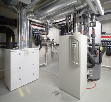 <p>
Der Technikraum des Wohnhauses ist die Schaltzentrale für die Energiesysteme. Das Vallox-Lüftungsgerät für die kontrollierte Wohnungslüftung (links) erzielt durch einen Kreuz-Gegenstrom-Wärmetauscher einen Wärmerückgewinnungsgrad bis 90 %. Die Wärmepumpe (Mitte) nutzt das thermisch aktive Kiesbett unter dem Fundament als Wärmequelle.
</p>

<p>
Alle Bilder: Heinemann GmbH 
</p>