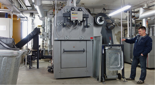 



Für die Grundlast wurde in der Heizzentrale ein Hackschnitzelkessel mit 390 kW installiert. Links im Bild ist die automatische Brennstoffzufuhr zu erkennen, rechts die automatische Ascheaustragung. 
