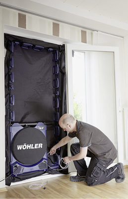 
Das Messgerät wird luftdicht in eine Tür oder ein Fenster eingebaut. Zur Ermittlung des Differenzdrucks wird ein Messschlauch nach außen und ein weiterer ins Gebäude verlegt. Zu Beginn der Messung misst das Gerät den natürlichen Differenzdruck. Dafür bleibt der Ventilator zunächst mit einer Haube abgedeckt.
