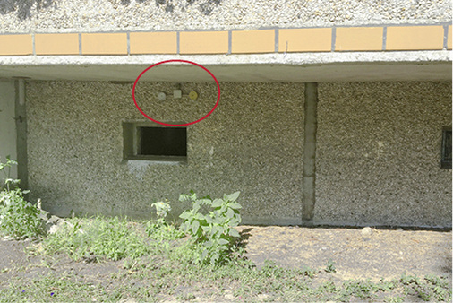 



8
 Regelwidrige Montage des Außentemperaturfühlers auf der Gebäudesüdseite, gefangen unter einer Balkonplatte im unmittelbaren Ausströmbereich der Warmluft aus dem Hausanschlussraum (siehe roter Kreis).
