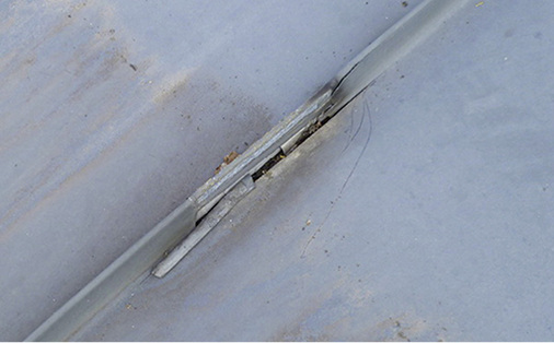 



14
 Nach dem Entfernen der Befestiger wird allerdings der Riss am Stehfalz aufgrund behinderter thermischer Ausdehnung sichtbar.
