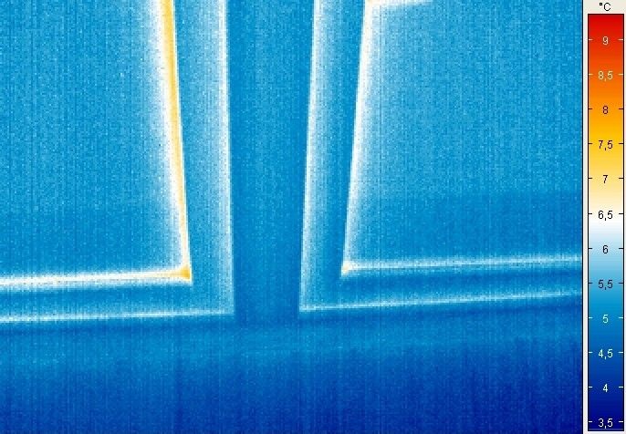 Detailaufnahme des unteren Randbereichs der Thermoplus III S3 Verglasung: Im Vergleich zum herkömmlichen Aluminiumabstandshalter sind beim thermisch verbesserten Abstandhalter die Wärmeverluste im Randbereich der Verglasung stark reduziert. Die mittleren und unteren weißen Bereiche zeigen den Wärmeverlust durch die Fuge zwischen Flügel und Rahmen. - Flachglas MarkenKreis - © Flachglas MarkenKreis
