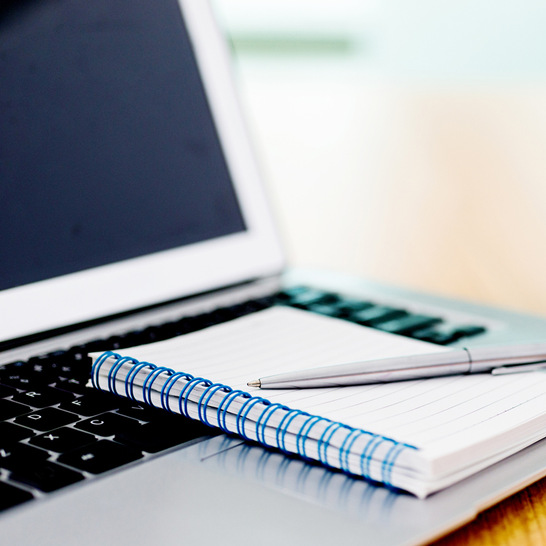 Laptop with pen and spiral notebook on desk. - © Getty Images/iStockphoto/baona
 Laptop with pen and spiral notebook on desk.
