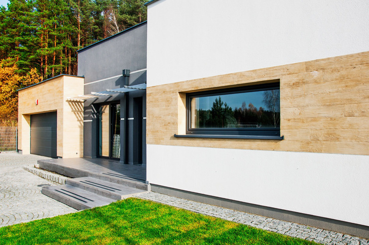 Materialkombination aus Putzfläche und Holzbekleidung? Gut getäuscht! Auch Putz kann Holz, wie diese Putzfassade mit CreativTop von Baumit beweist. 