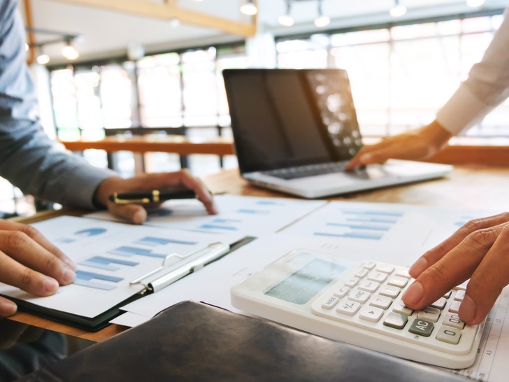 Business executives analysis data document and calculating about fee tax at a office