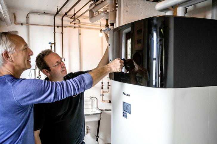 Heizungsinstallateur Oliver Fleig (rechts) erklärt Hausbesitzer Marc Freiburger die Regelung der Daikin Altherma 3 H HT.