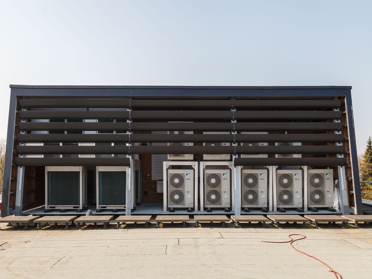 Bei der Genter Marketingagentur Claerhout stehen die Wärmepumpen-Außengeräte unter einem Schutzbau auf dem Flachdach. Sonnensegel schützen sie vor Überhitzung. - © Studio Claerhout
