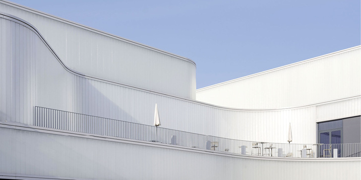Eine geschwungene „Eisfassade“ aus Profilglas mit transparenter Wärmedämmung von Wacotech prägt die Architektur der Vaudeoise Aréna bei Lausanne.