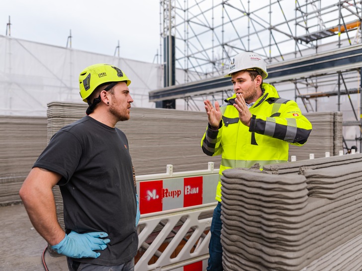 Firmengründer Yannick Maciejewski (links) und Fabian Rupp diskutieren über den 3D-Betondruck von Gebäuden. - © Rupp Gebäudedruck

