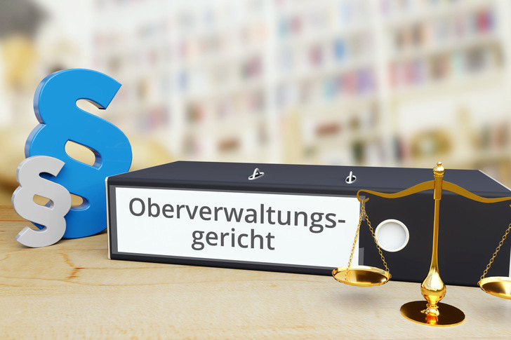 Oberverwaltungsgericht – Recht/Gesetz. Ordner auf Schreibtisch mit Beschriftung neben Paragraf und Waage. Anwalt
