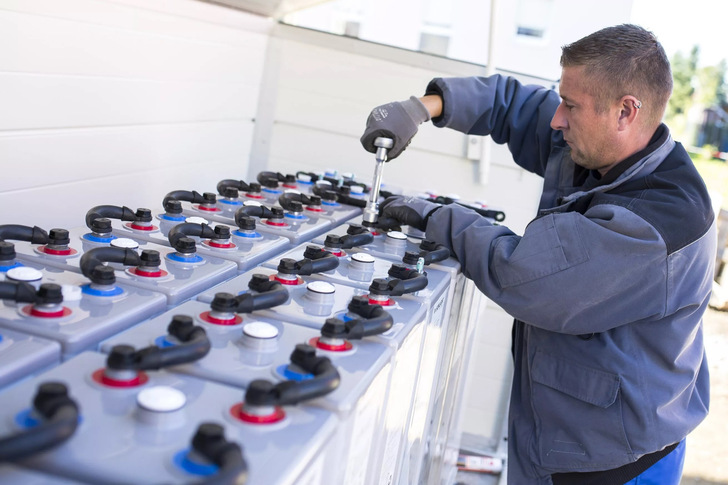 Ein Fachmann installiert einen großen Blei-Gel-Speicher in einem energieautarken Einfamilienhaus in Freiberg. - © BSW
