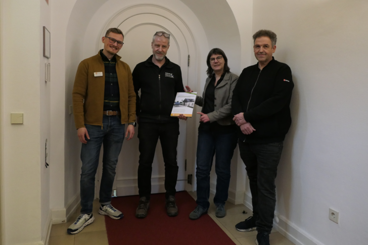 GIH-NRW-Vorsitzende Gisela Renner überreicht Neumitglied Andreas Lippertz (zweiter von rechts) das Energieberatungshandbuch. Lennart Feldmann (links) und Bernd Kohl (rechts) gehören zum GIH-Vorstand in Nordrhein-Westfalen.
