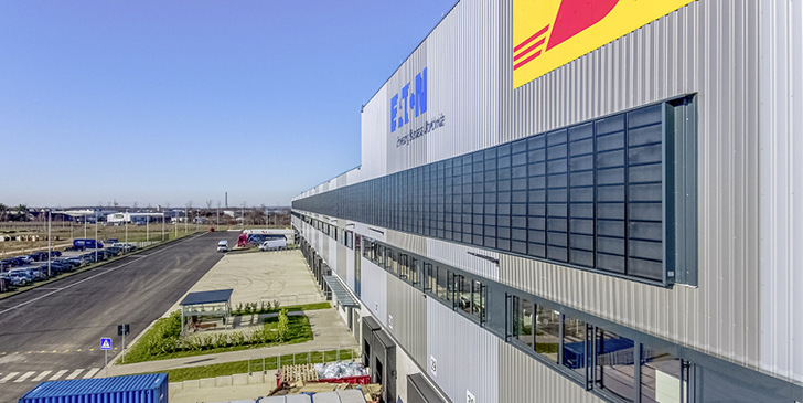 Bei DHL in Rheinbach hält eine 610 m² große Lubi Wall-Luft­kollektorfläche das 29 100 m² umfassende Logistik­zentrum 19 °C warm.