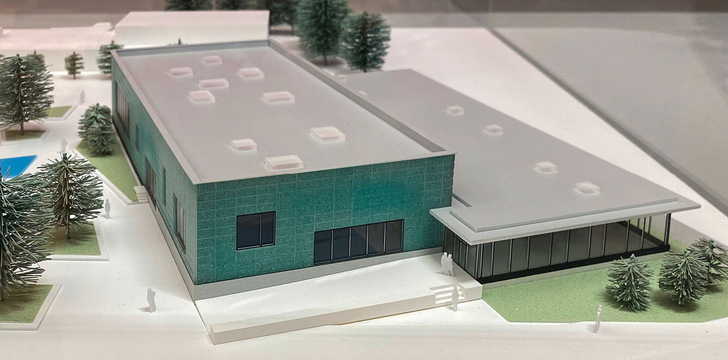 1 Klare Struktur: Das Hallenbad mit grün eingefärbten Modulen überragt die verglaste Nebenzone.