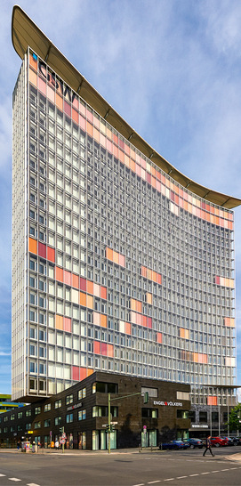 Eines der Lieblingsprojekte von Rudi Scheuermann: das GSW-Hochhaus in 
Berlin mit unkonventionell konkav-konvexe Hochhausscheiben, 1999 vor ein Punkt­hochhaus von 1961 gesetzt, inklusive preisgekrönter Sonnenschutzfassade mit farbigen Metall-Lamellen.