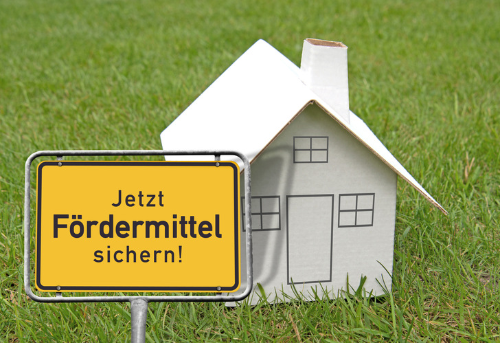 Ortsschild, Kartonhaus „Jezt Fördermittel sichern!“