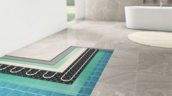 Eine Fußbodenheizung baut sich aus mehreren Elementen auf: Untergrund, Grundierung, Heizsystem, Ausgleichsmasse, Grundierung, Kleber, Bodenbelag.