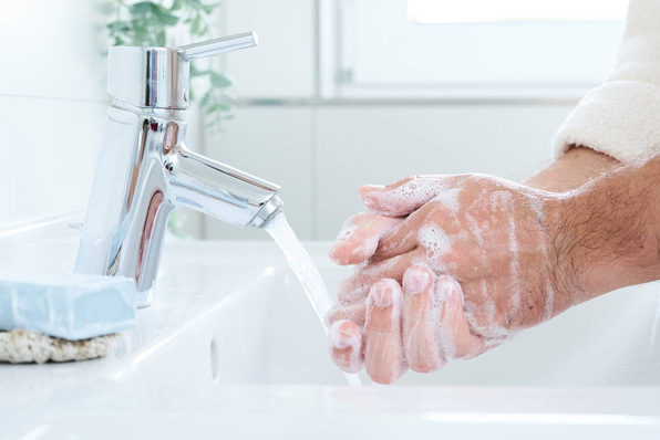 Person, die sich unter fließendem Wasser in einem Waschbecken die Hände mit Seife wäscht. - © Techem / Miriam Lindthaler